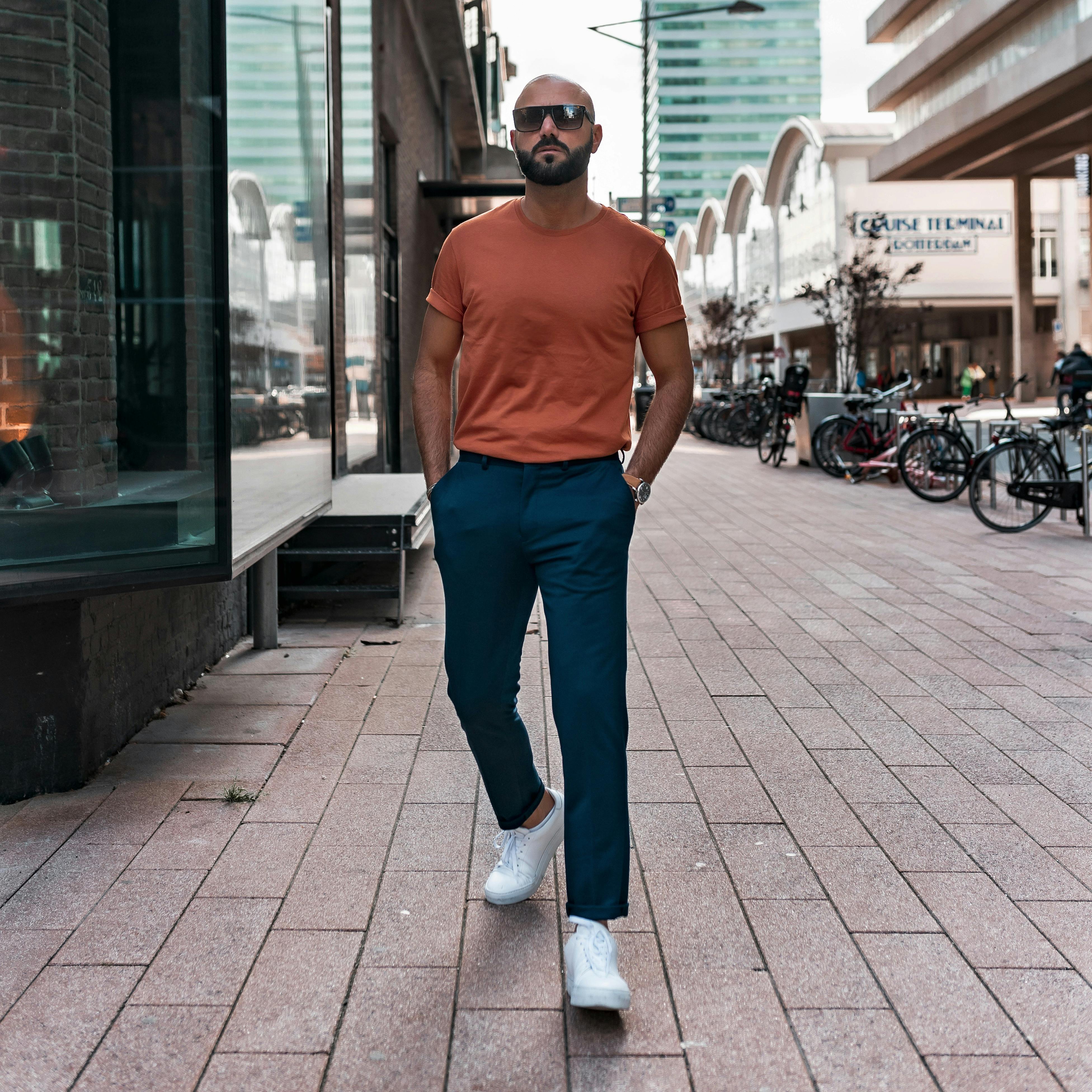 men wearing casual clothes, orange t-shirt and blue chinos